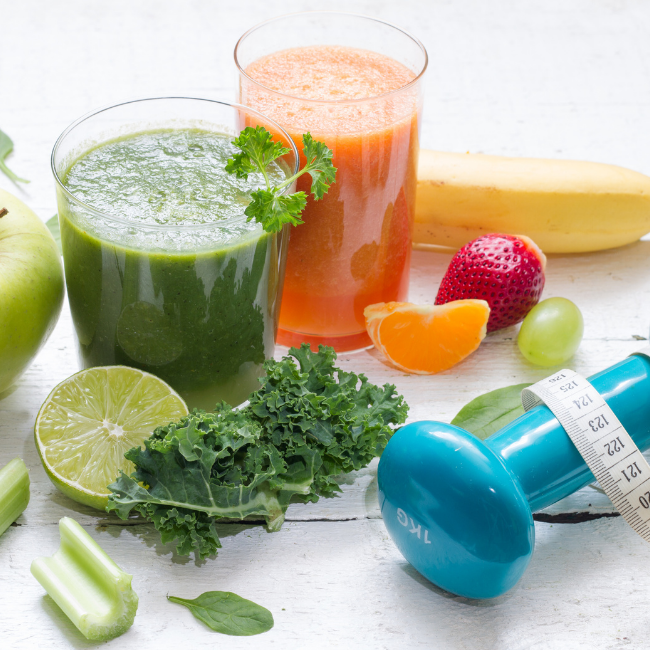 green juice, carrot juice and a dumbbell